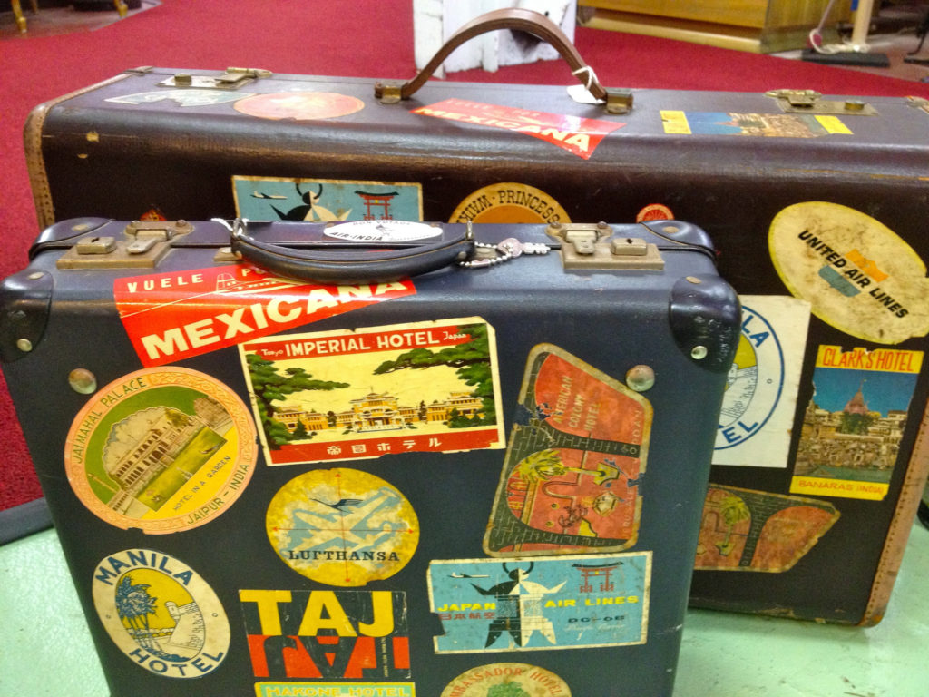Two leather suitcases covered with stickers