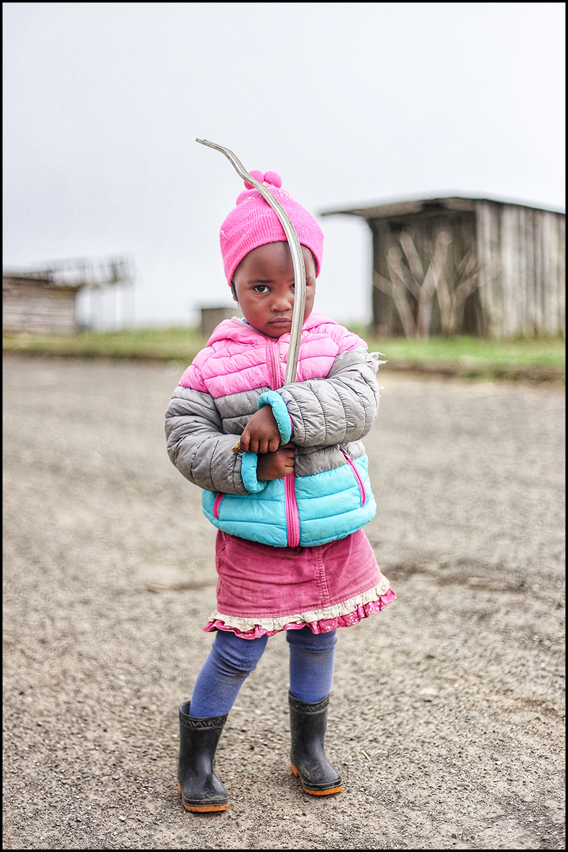 A travel storytelling slideshow featuring Murugi's photography: 1 of 9 - A little girl holds poses in Kenya.