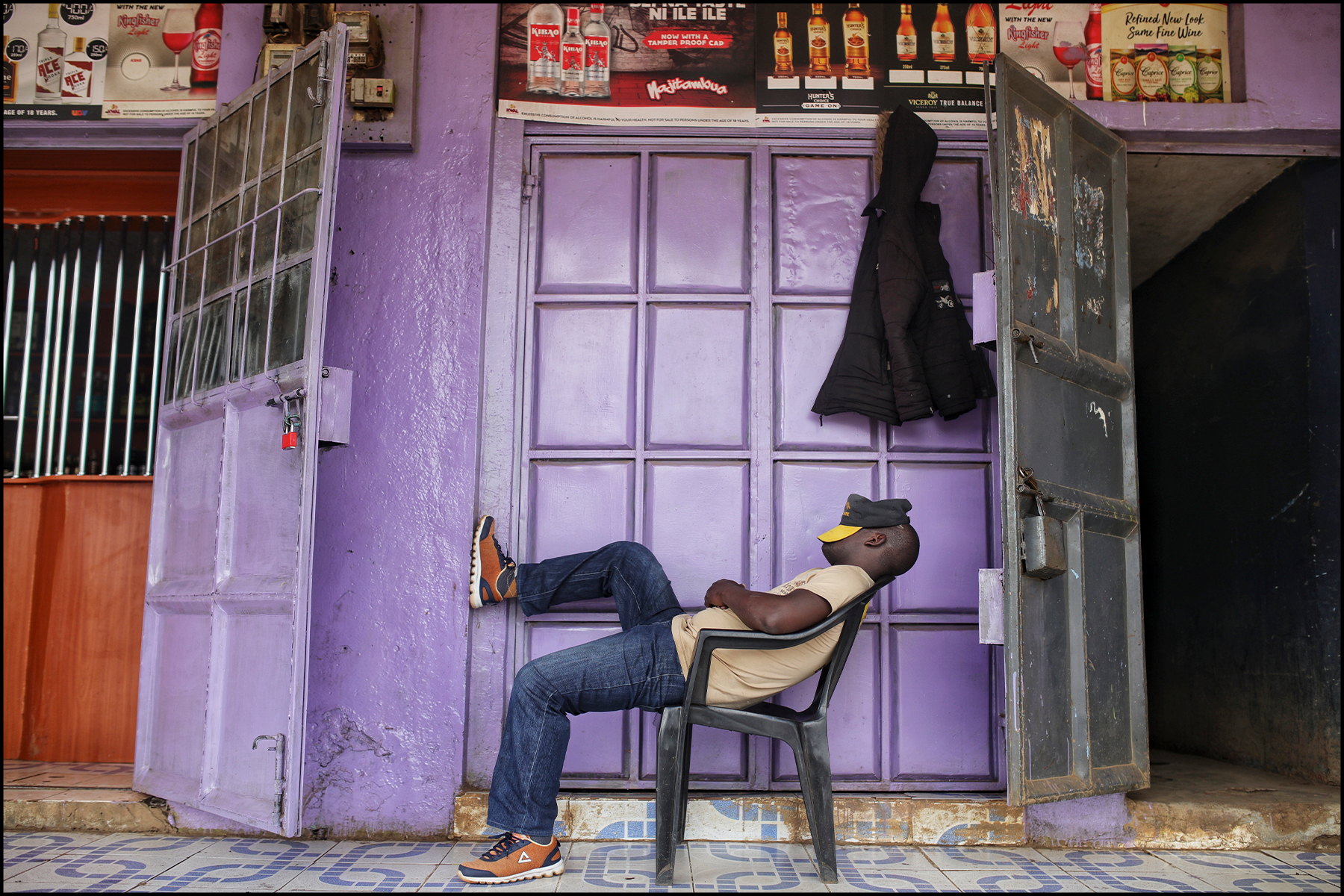 A travel storytelling slideshow featuring Murugi's photography: 1 of 9 - A man takes nap in a chair in Kenya.